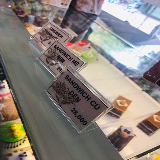 Bảng tên mica nghiêng ghi tên bánh sandwich trên quầy