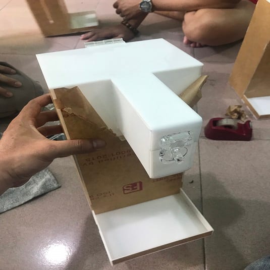 Tay thợ đang ghép dán thành chữ nổi mica trắng