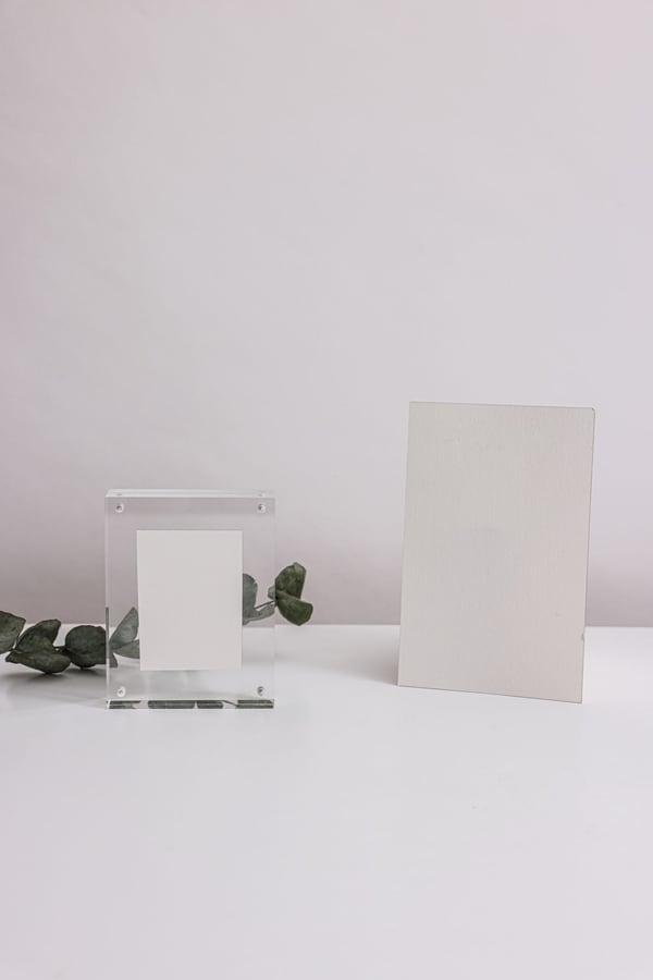 Khối mica trong đặt cạnh tấm thẻ trắng trên bàn
