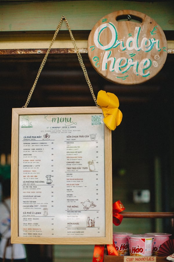 Bảng thực đơn trong khung đặt cạnh biển gọi món tại quầy
