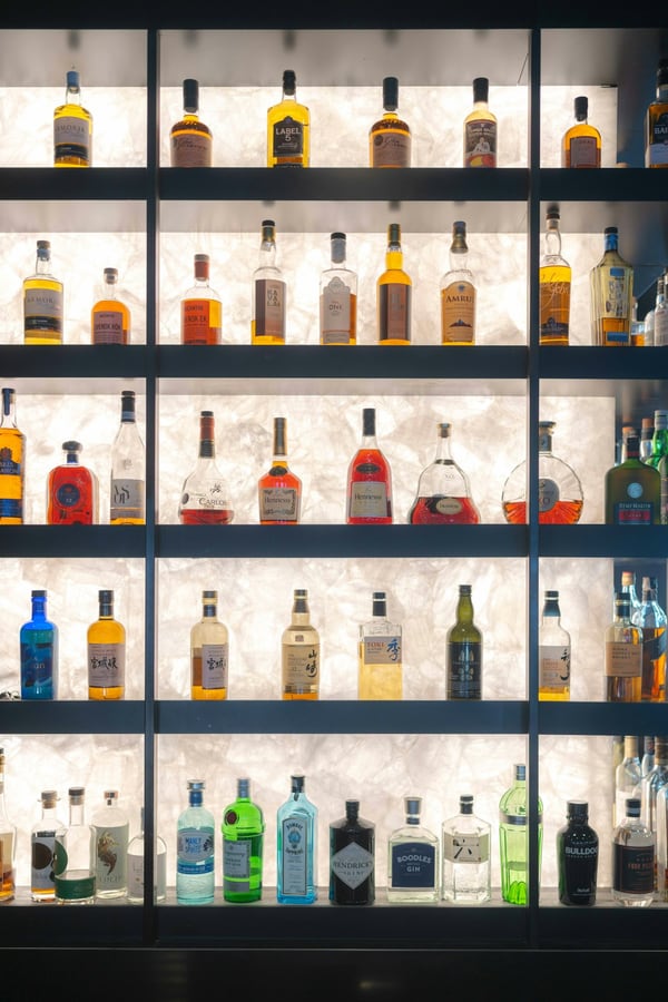 Quầy bar với kệ rượu nhiều tầng được chiếu sáng từ phía sau